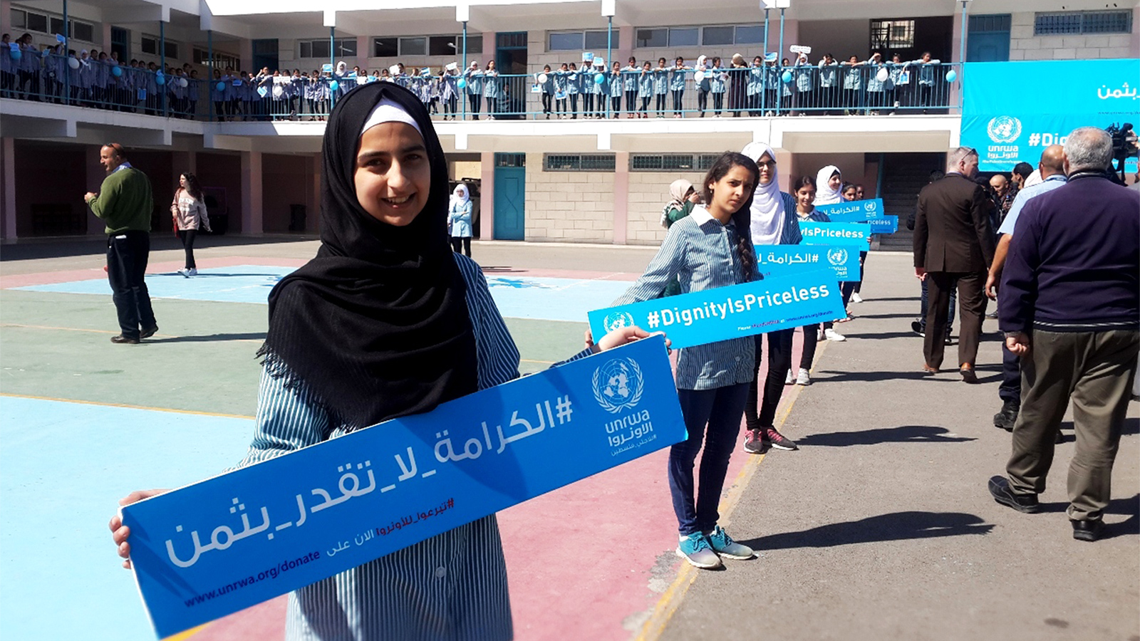 ‪طالبات بمدرسة مخيم الأمعري للاجئين يرفعن نداءات الأونروا‬ (الجزيرة)