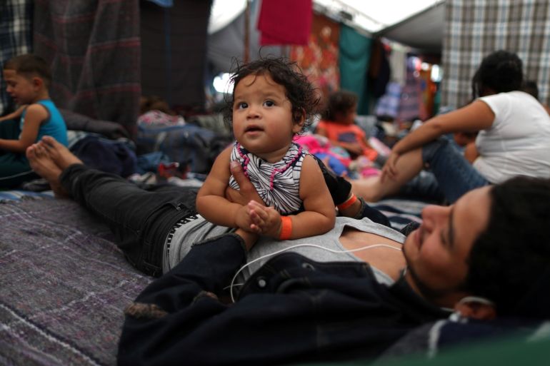 Cesar Elvir, 20, from Honduras, and his one-year-old cousin, Ahslyn, part of a caravan of thousands of migrants from Central America trying to reach the United States, rest in temporary shelter in Tijuana, Mexico, November 24, 2018. REUTERS/Lucy Nicholson