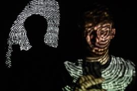 LONDON, ENGLAND - AUGUST 09: In this photo illustration, a thumbprint is projected onto a man as he holds a mobile phone on August 09, 2017 in London, England. With so many areas of modern life requiring identity verification, online security remains a constant concern, especially following the recent spate of global hacks. (Photo by Leon Neal/Getty Images)