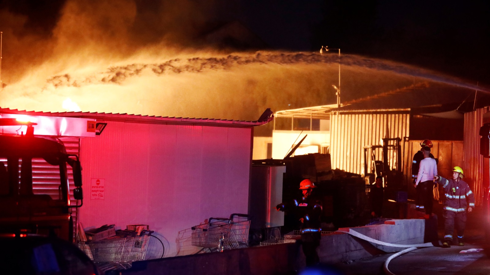 فرق الإطفاء الإسرائيلية تحاول إخماد النيران في منزل بمستوطنة سديروت بعد إصابته بأحد صواريخ المقاومة (رويترز) 
