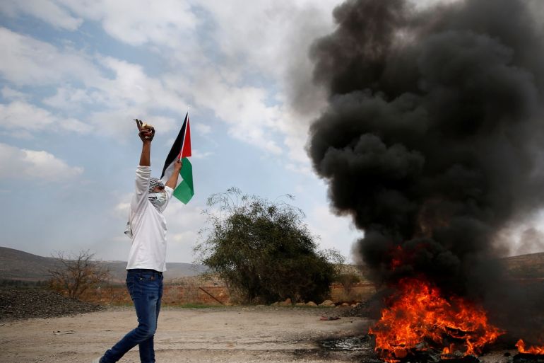 A Palestinian demonstrator gestures during clashes with Israeli troops at a protest against Israeli land seizures for Jewish settlements, near Ramallah in the occupied West Bank November 30, 2018. REUTERS/Mohamad Torokman