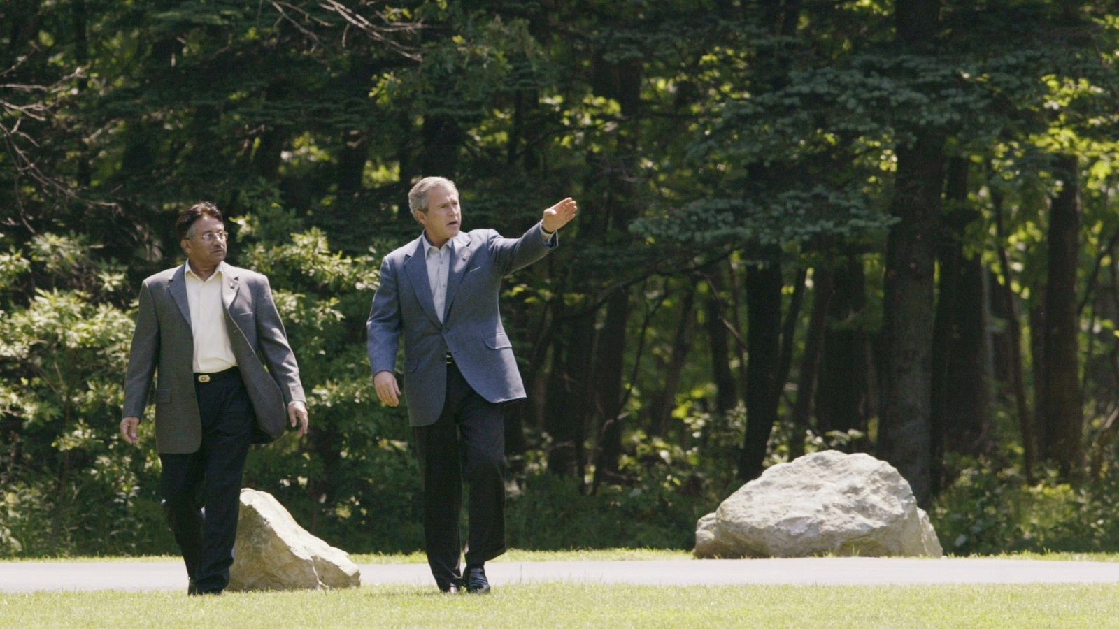 جورج بوش الابن (يمين) يتجول مع برويز مشرف في منتجع كامب ديفد عام 2003 (رويترز)