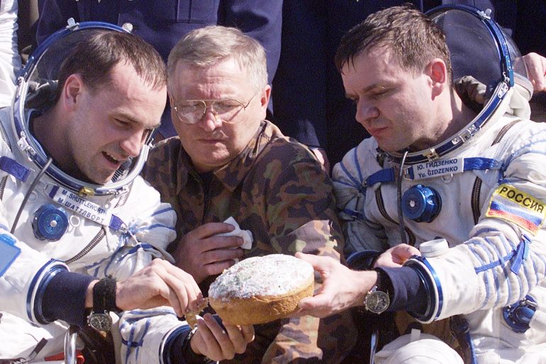 404948 04: South Africa space tourist Mark Shuttleworth (L) picks off a piece of cake handed to him by fellow space traveler Russian cosmonaut Yuri Gidzenko after landing May 5, 2002 near Arkalyk, Kazakhstan. Shuttleworth, along with fellow space travelers, Italian astronaut Roberto Vittori and Russian cosmonaut Yuri Gidzenko landed safely after spending eight days aboard the International Space Station. (Photo by Oleg Nikishin/Getty Images)