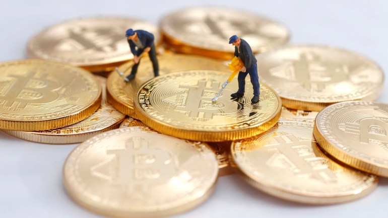 Small toy figures are seen on representations of the Bitcoin virtual currency in this illustration picture, December 26, 2017. REUTERS/Dado Ruvic/Illustration