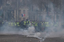 French police intervene in Yellow Vests' protest in Paris- - PARIS, FRANCE - DECEMBER 08: French police intervene in yellow vests' (gilets jaunes) protest against rising oil prices and deteriorating economic conditions along the Champs-Elysees Avenue in Paris, France on December 08, 2018. French police used pepper spray against protesters.