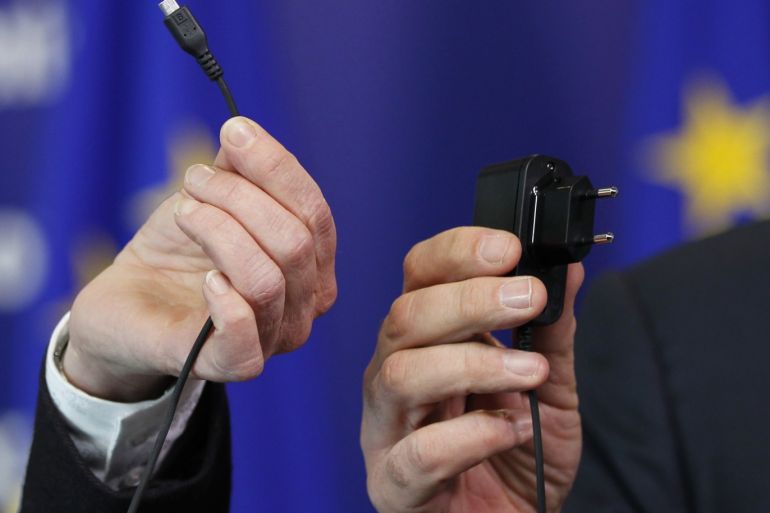 European Commissioner for Industry and Entrepreneurship Antonio Tajani and Bridget Cosgrave (L), Director General of DigitalEurope, display an harmonised mobile phone charger during a news conference at the EU Commission headquarters in Brussels February 8, 2011. REUTERS/Francois Lenoir (BELGIUM - Tags: BUSINESS IMAGES OF THE DAY)