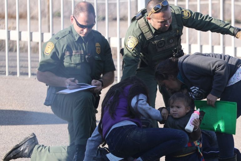 U.S. Customs and Border Protection (CBP) officials detain a migrant woman and children, part of a caravan of thousands from Central America trying to reach the United States, after they crossed illegally with other migrants from Mexico to the U.S, at International Friendship Park, in San Diego, U.S., December 7, 2018. Picture taken from Tijuana, Mexico. REUTERS/Mohammed Salem