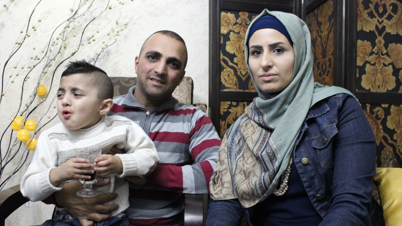 ‪خالد الجنيدي وزوجته إيناس مع طفلهما المصاب بالتوحد توفيق‬ (الجزيرة)