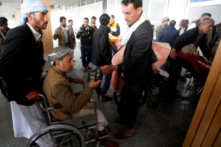 A wounded Houthi fighter, on a wheelchair, holds his passport at Sanaa airport during his evacuation from Yemen, December 3, 2018. REUTERS/Mohamed al-Sayaghi
