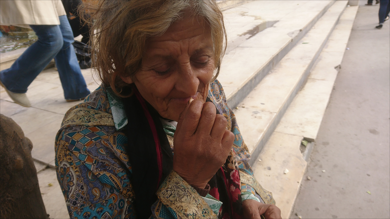 ‪امرأة بأحد شوارع تونس تضع النفّة في فمها‬ (الجزيرة)