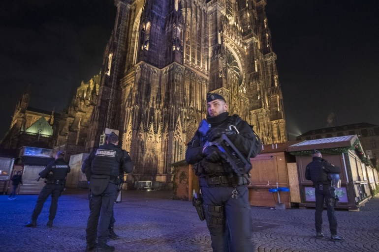 STRASBOURG, FRANCE - DECEMBER 12: Police officers patrol in front of the cathedral near the Christmas market where the day before a man shot 14 people, killing at least three, on December 12, 2018 in Strasbourg, France. Police have identified the man as Cherif Chekatt, a French citizen on a police terror watch-list. Chekatt exchanged gunfire with soldiers after the attack, is reportedly injured and is still on the loose. (Photo by Thomas Lohnes/Getty Images)
