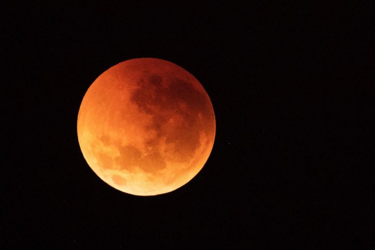 SYDNEY, AUSTRALIA - JULY 28: The moon is seen turning red over the Sydney skyline during a total lunar eclipse on July 28, 2018 in Sydney, Australia. The lunar eclipse was the longest of the 21st century lasting 1 hour and 43 minutes. (Photo by Cameron Spencer/Getty Images)