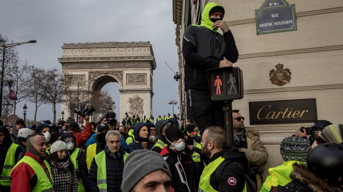 PARIS, FRANCE - DECEMBER 08: Protesters chant slogans during the 'yellow vests' demonstration on the Champs-Elysées near the Arc de Triomphe on December 8, 2018 in Paris France. ''Yellow Vests' ('Gilet Jaunes' or 'Vestes Jaunes') is a protest movement without political affiliation which was inspired by opposition to a new fuel tax. After a month of protests, which have wrecked parts of Paris and other French cities, there are fears the movement has been infiltr