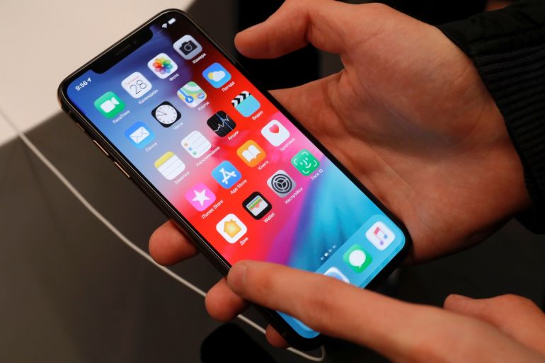 A customer tests a smartphone during the launch of the new iPhone XS and XS Max sales at