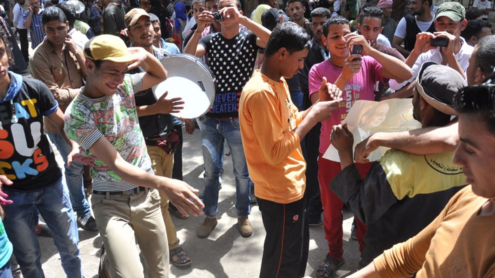شباب يرقصون على إيقاع أغاني المهرجانات أمام لجان الانتخابات الرئاسية (الجزيرة)