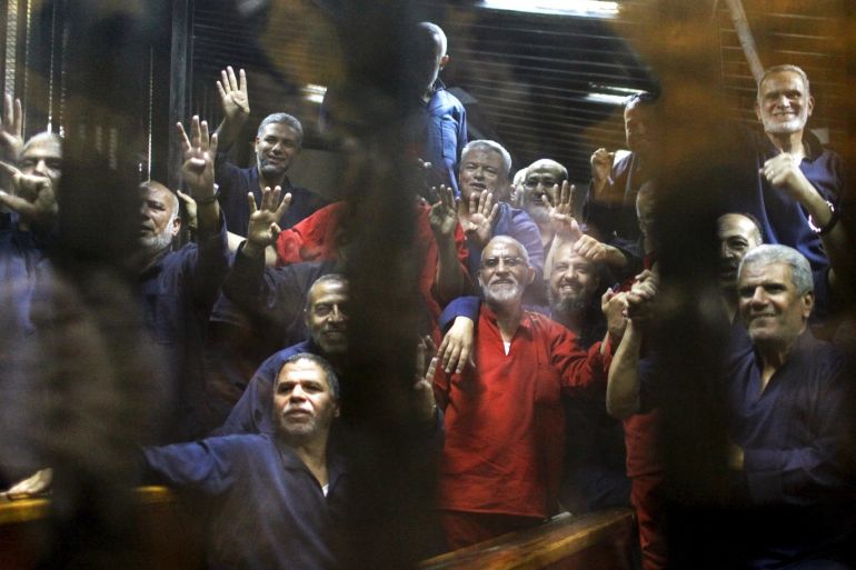 Muslim Brotherhood members including the general guide of the Muslim Brotherhood, Mohamed Badie, gesture from behind bars after their verdict at a court on the outskirts of Cairo, Egypt June 16, 2015. An Egyptian court sentenced deposed President Mohamed Mursi to death on Tuesday on charges of killing, kidnapping and other offences during a 2011 mass jail break.The general guide of the Muslim Brotherhood, Mohamed Badie, and four other Brotherhood leaders were also hande