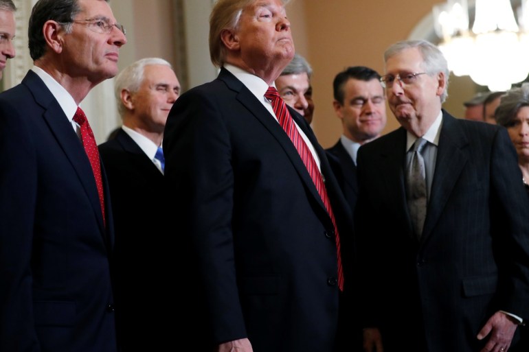 U.S. President Donald Trump listens to questions from reporters as Sen. John Barrasso (R-WY) (L), Vice President Mike Pence, Senate Majority Leader Mitch McConnell and other Republican senators look on as the president departs after addressing a closed Senate Republican policy lunch while a partial government shutdown enters its 19th day on Capitol Hill in Washington, U.S., January 9, 2019. REUTERS/Jim Young