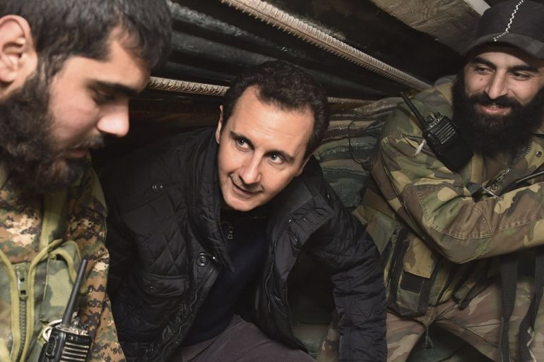 Syrian President Bashar al-Assad (C) talks to soldiers during a visit to Jobar, northeast of Damascus, in this handout photograph distributed by Syria's national news agency SANA on January 1, 2015. Al-Assad visited a district on the outskirts of Damascus and thanked soldiers fighting