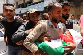 GAZA CITY, GAZA - MAY 15: (EDITORS NOTE: Image depicts death.) The father of eight-month-old Leila Anwar Ghandoor, who died in the hospital on Tuesday morning from tear gas inhalation, carries her to burial on May 15, 2018 in Gaza City, Gaza. Anwar was with a relative during the violence at the Gaza-Israel border yesterday when tear gas canisters were fired at crowds. Israeli soldiers killed over 50 Palestinians and wounded over a thousand as demonstrations on the Gaza-Israel border coincided with the controversial opening of the U.S. Embassy in Jerusalem. This marks the deadliest day of violence in Gaza since 2014. Gaza's Hamas rulers have vowed that the marches will continue until the decade-old Israeli blockade of the territory is lifted. (Photo by Spencer Platt/Getty Images)