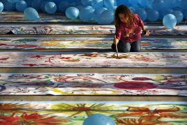A child paints a flower on the world's longest painting ever made by children, in Bucharest November 18, 2006. A Guinness World Records representative who was at the scene confirmed the record at the event, which was organised by the United Nations Children's Fund (UNICEF). REUTERS/Bogdan Cristel (ROMANIA)