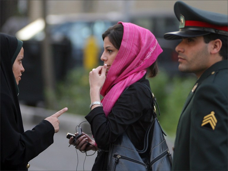 Iranian policewoman (L) warns a woman about her clothing and hair during a crackdown to enforce Islamic dress code رويترز