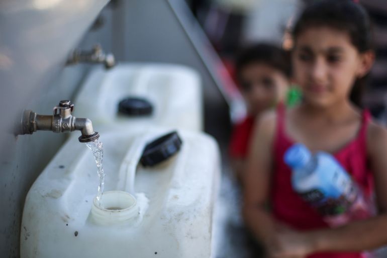Water shortage in Gaza- - GAZA CITY, GAZA - AUGUST 03: Palestinian children wait next to water tank truck to collect water for their families as water crisis worsens in Gaza City, Gaza on May 03, 2018. The EU started operations at the biggest solar energy field in the Gaza Strip to fuel projects that will provide drinking water to people in dire need, the European Commission (EC) announced on Thursday. With the new energy field and new investments foreseen, drinking water is expected to eventually reach 250,000 people in Southern Gaza by 2020, according to the EC.