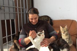 هدى بوشهدة عاشقة القطط والكلاب بتونس تحتضن إحدى قططها وسط عشرات من حيواناتها الأليفة (الجزيرة-أرشيف)
