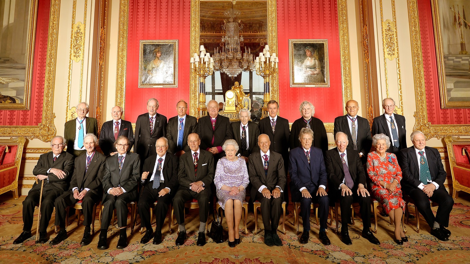 صورة جماعية التقطت في 2015 للحاصلين على وسام الاستحقاق تتوسطهم الملكة إليزابيث، وعطية هو الرابع من اليسار في الصف الأول (غيتي)