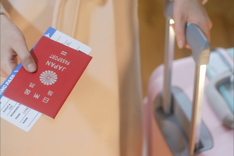 Girl holds Japan passport and boarding pass