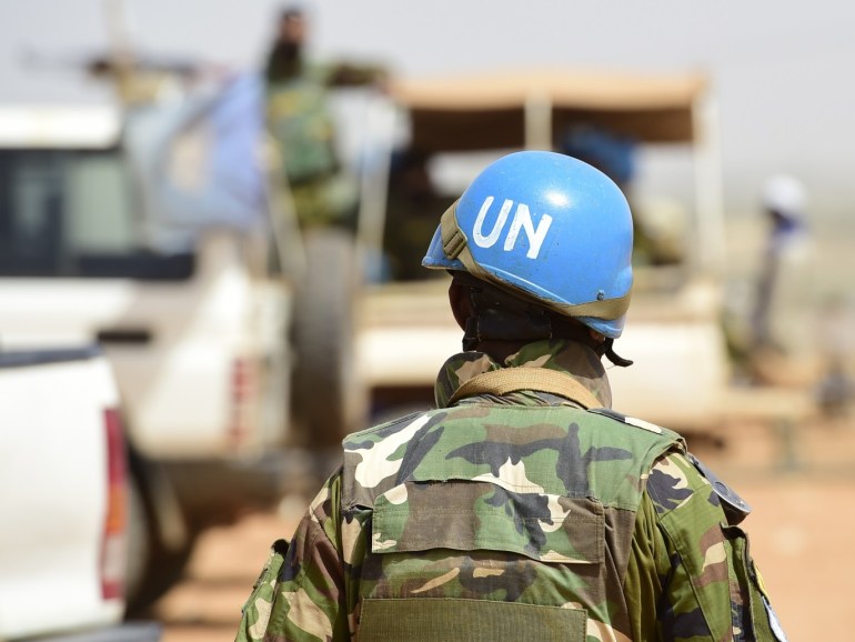 GAO, MALI - MARCH 07: A Bangladeshi United Nations soldier walks by a car during the weekly cattle market on March 7, 2017 in Gao, Mali. Each week locals and Touareg nomads gather at the market to trade their cattle including Camels, Cows, Sheep and clothing. U.N.-led MINUSMA (United Nations Multidimensional Integrated Stabilization Mission) troops are assisting the Malian government in its struggle against rebels that include a Tuareg movement (MNLA) and several Islami