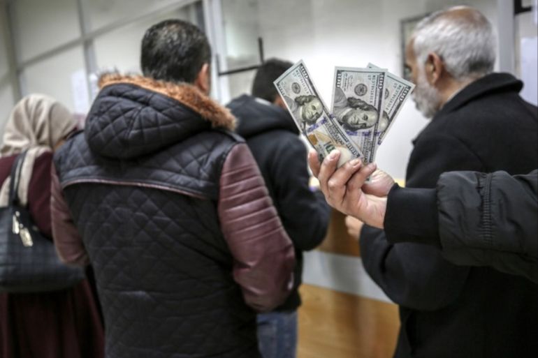 epa07215223 Goverment employees in Gaza Strip receive 50 percemt of their overdue salaries donated by Qatar, at the main Gaza post office, Gaza City, 07 December 2018. Hamas received 15 million US dollars from Qatar to help pay the salaries of the territory's civil servants EPA-EFE/MOHAMMED SABER