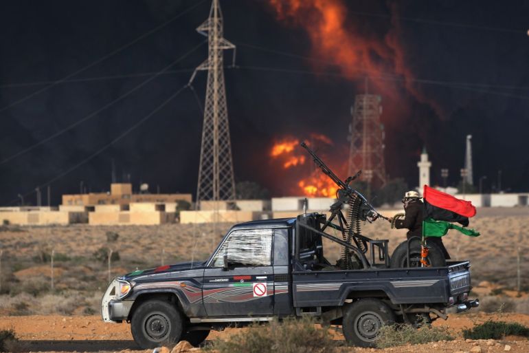 RAS LANUF, LIBYA - MARCH 09: Libyan rebels attack government troops as a facility burns on the frontline on March 9, 2011 near Ras Lanuf, Libya. The rebels pushed back government troops loyal to Libyan leader Muammar Gaddafi towards Ben Jawat. (Photo by John Moore/Getty Images)