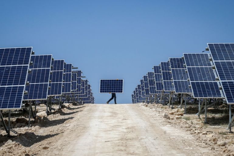 Solar power plant construction in Turkey's Van- - VAN, TURKEY - JULY 17 : A worker carries solar panel at the construction site of 20MW solar power plant projects of Akfen Renewable Energy in Edremit district of Van, Turkey on July 17, 2018. Akfen Renewable Energy company establishes two different solar power plants on an area covering 400 decares. Constructions of the 20 MW plants, with staff of 135, are expected to be completed in two months.