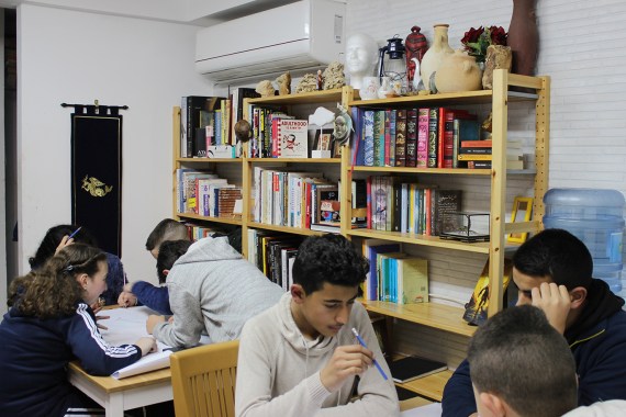 6-أطفال مجلس الخيال خلال الورشة وخلفهم مكتبتهم المتخصصة في الخيال وهي الأولى من نوعها في القدس(الجزيرة نت) copy.jpg