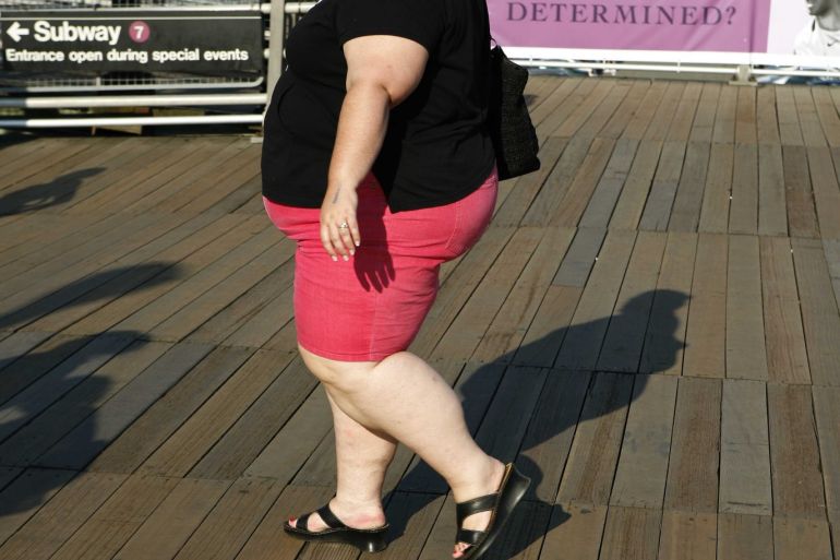 A woman walks along the boardwalk while leaving the U.S. Open tennis tournament in New York in this September 4, 2007 file photo. About two-thirds of American adults are overweight or obese, putting them at an increased risk for diabetes, hypertension, heart disease, osteoarthritis, stroke, gallbladder disease, sleep apnea and respiratory problems and even some cancers. The direct and indirect costs of obesity is $117 billion each year, according to a 2000 report by the U.S. Surgeon General. To match feature USA-OBESITY/ REUTERS/Lucas Jackson/Files (UNITED STATES)