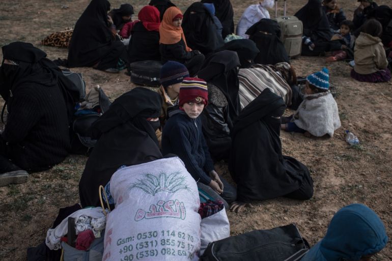 BAGOUZ, SYRIA - FEBRUARY 09: Civilians who have fled fighting in Bagouz sit on the ground after being screened and interviewed by members of the Syrian Democratic Forces (SDF) at a makeshift screening point in the desert on February 9, 2019 in Bagouz, Syria. After weeks of fighting the Syrian Democratic Forces (SDF) announced the start of a final operation to oust ISIS from Bagouz the last village held by the extremist group. (Photo by Chris McGrath/Getty Images)