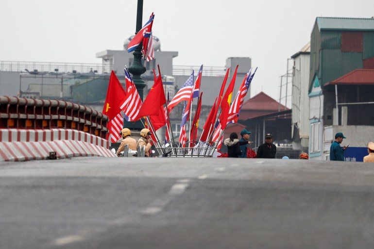 The flags of Vietnam, U.S. and North Korea are seen near a road closure as the motorcade (not pictured) of North Korea's leader Kim Jong Un travels towards his hotel, ahead of the North Korea-U.S. summit in Hanoi, Vietnam February 26, 2019. REUTERS/Kim Kyung-Hoon