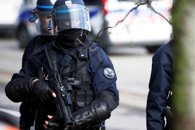 A French police officer in riot gear holds a flash-ball gun during a demonstration of the