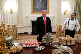 U.S. President Donald Trump stands in front of fast food for the 2018 College Football Playoff National Champion Clemson Tigers in the State Dining Room of the White House in Washington, U.S., January 14, 2019. REUTERS/Joshua Roberts