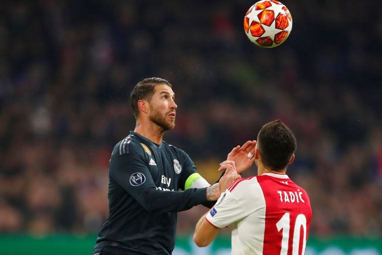 Soccer Football - Champions League Round of 16 First Leg - Ajax Amsterdam v Real Madrid - Johan Cruijff Arena, Amsterdam, Netherlands - February 13, 2019 Ajax's Dusan Tadic in action with Real Madrid's Sergio Ramos REUTERS/Wolfgang Rattay