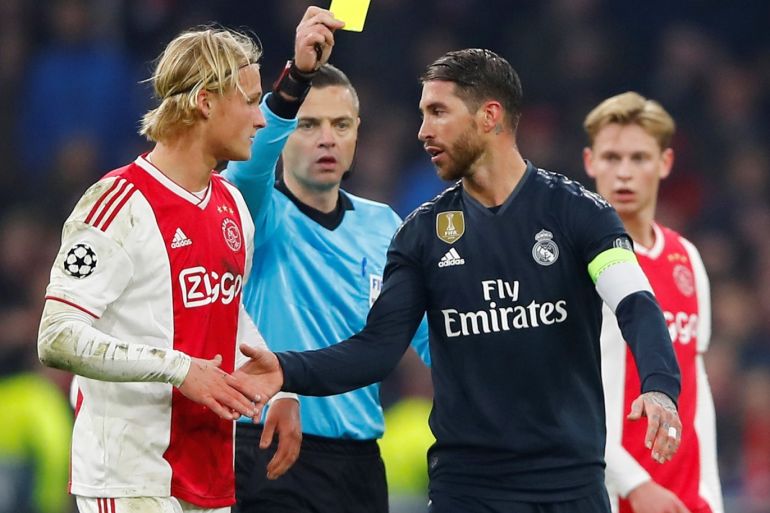 Soccer Football - Champions League Round of 16 First Leg - Ajax Amsterdam v Real Madrid - Johan Cruijff Arena, Amsterdam, Netherlands - February 13, 2019 Real Madrid's Sergio Ramos is shown a yellow card by referee Damir Skomina as Ajax's Kasper Dolberg looks on REUTERS/Wolfgang Rattay