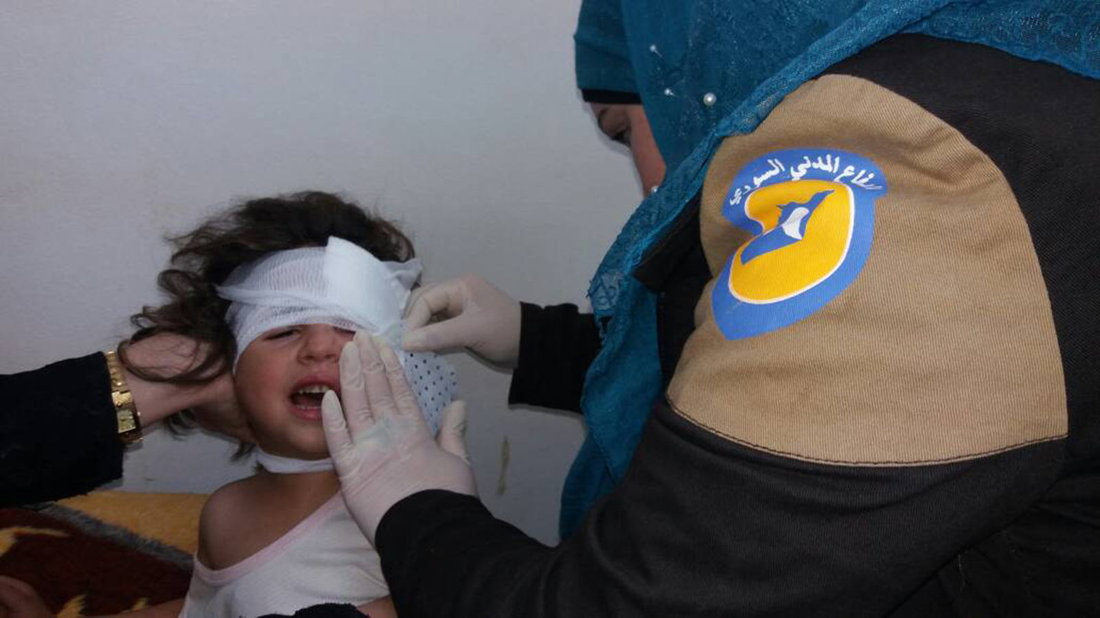‪متطوعة في الخوذ البيضاء أثناء تقديم الإسعافات لطفلة أصيبت بقصف للنظام على إدلب‬ (الجزيرة)