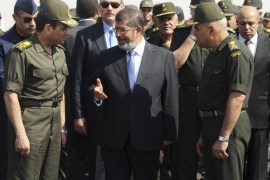 Egypt's President Mohamed Mursi (C) speaks with Defence Minister Abdel Fattah al-Sisi (L) and General Sedky Sobhi (R), chief of staff to Egypt's Supreme Council of the Armed Forces (SCAF), during his visit to the 6th armoured division of the second army, near Ismailia, some 75 miles (121 km) north of Cairo October 10, 2012. Picture taken October 10, 2012. REUTERS/Egyptian Presidency/Handout (EGYPT - Tags: POLITICS MILITARY) FOR EDITORIAL USE ONLY. NOT FOR SALE FOR MA