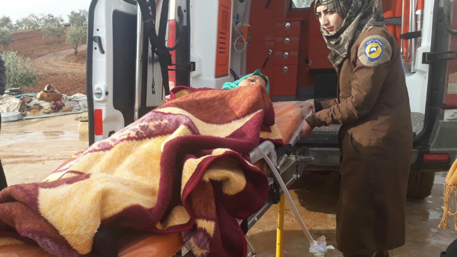 ‪متطوعة تشارك في إسعاف سيدة مصابة بجروح عقب غارة جوية للنظام السوري على إدلب‬ (الجزيرة)