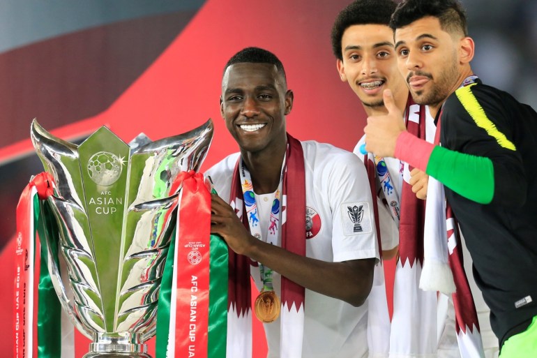 Soccer Football - AFC Asian Cup - Final - Japan v Qatar - Zayed Sports City Stadium, Abu Dhabi, United Arab Emirates - February 1, 2019 Qatar's Almoez Ali and team mates pose with the trophy as they celebrate winning the Asian Cup REUTERS/Thaier Al-Sudani