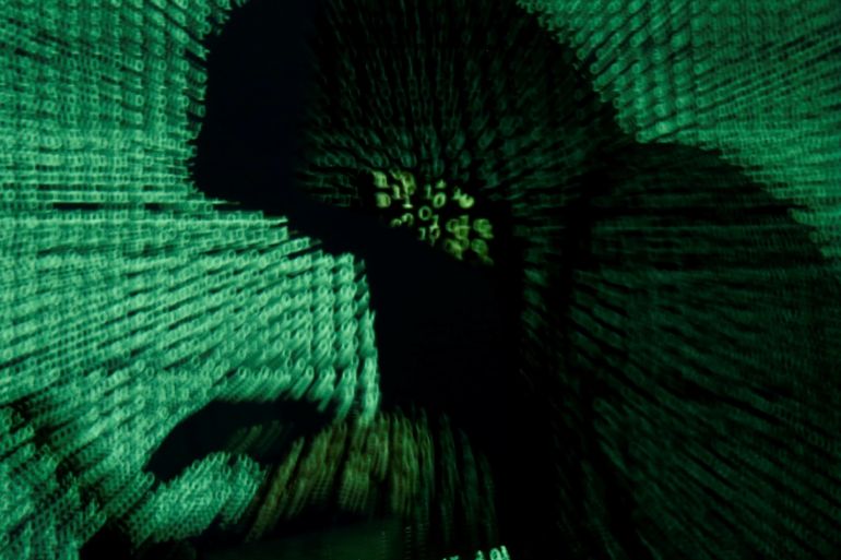 A man holds a laptop computer as cyber code is projected on him in this illustration picture taken on May 13, 2017. Capitalizing on spying tools believed to have been developed by the U.S. National Security Agency, hackers staged a cyber assault with a self-spreading malware that has infected tens of thousands of computers in nearly 100 countries. REUTERS/Kacper Pempel/Illustration