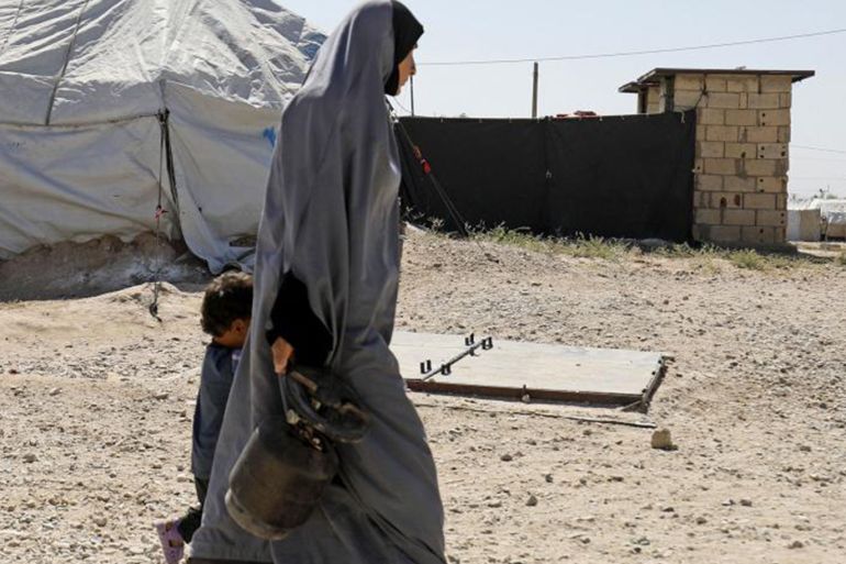 امرأة تمشي مع طفل في مخيم روج، الذي يأوي زوجات وأطفال عناصر "الدولة الإسلامية" (داعش)، شمال شرق سوريا، سبتمبر/أيلول 2018. © 2018 دليل سليمان/أ ف ب/غيتي إيمجز