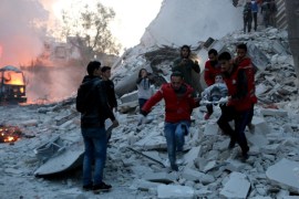 Airstrikes in Syria's Idlib- - IDLIB, SYRIA - MARCH 13: A survivor kid is being moved away from the site by civil defense team member after an airstrike hits the city center in Syria's northwestern Idlib province on March 13, 2019.