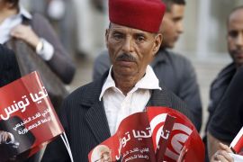 A supporter of the Nidaa Tounes party holds pictures of President Beji Caid Essebsi, in Tunis, Tunisia November 3, 2015. Tensions between two wings of Nidaa Tounes, whose name means Call of Tunis, spilled over into violence last week when a party meeting descended into open fighting with fists and sticks. A split within Nidaa Tounes could trigger political instability in the country that launched the first of the Arab Spring revolutions in 2011. Thirty-two of Nidaa Tounes' 86 lawmakers have already threatened to break away in protest at what they see as attempts by President Beji Caid Essebsi, who founded the secular party in 2012, to impose his son Hafhed as its leader. The president's office rejects those accusations. REUTERS/Zoubeir Souissi