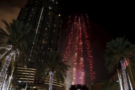 Fireworks explode over Dubai's Burj Khalifa, the tallest building in the world, during the New Year celebrations January 1, 2016, as the Address Downtown Dubai hotel and residential block, which had been engulfed by a fire, can be seen on the left. REUTERS/Ahmed Jadallah TPX IMAGES OF THE DAY